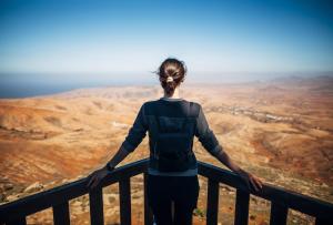 a woman standing on the top of a mountain at AVANTI Lifestyle Hotel - Only Adults in Corralejo