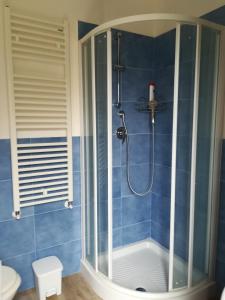 a shower in a bathroom with blue tiles at LA TERRAZZA SU ROMA in Zagarolo +25 photos