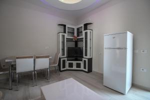 a kitchen with a refrigerator and a table with chairs at Apartments Romario in Sarandë