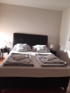 a bed with blankets and pillows on top of it at Apartments Thea in Mostar