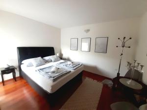 a bedroom with a bed with white sheets and a table at Apartments Thea in Mostar