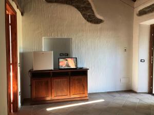 ein Zimmer mit einem Holzschrank, auf dem ein Bild hängt in der Unterkunft Li Casacci in Arzachena