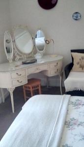 a bedroom with a white desk with mirrors on it at Aydon House in Alnwick