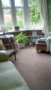 uma sala de estar com uma estante de livros e janelas em Aydon House em Alnwick