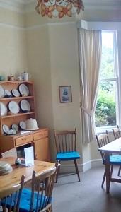 een eetkamer met een tafel en stoelen en een raam bij Aydon House in Alnwick