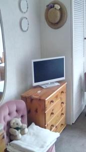 a teddy bear sitting in a chair next to a desk with a television at Aydon House in Alnwick