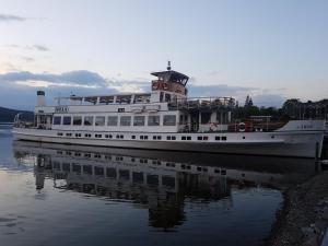 a ferry boat is docked in the water at Bowness Guest House in Bowness-on-Windermere