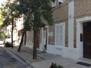 Ein kleines Mädchen geht eine Straße entlang neben einem Gebäude in der Unterkunft Perfume Do Mar in Porto San Giorgio