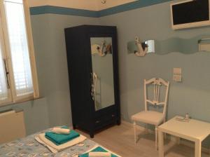 ein kleines Zimmer mit einem Spiegel und einem Stuhl in der Unterkunft Perfume Do Mar in Porto San Giorgio