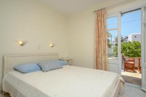 a bedroom with a bed and a large window at Orkos Blue Coast in Mikri Vigla