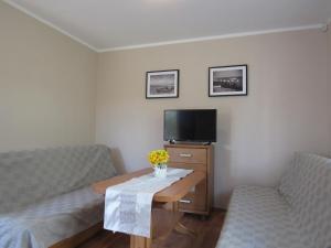 a living room with two chairs and a table and a tv at Manta Apartamenty in Sianozety