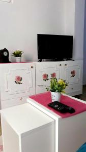 a living room with a tv and a table with flowers at Apartman Tatjana in Sutomore