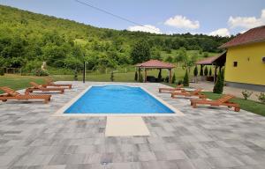 een zwembad met banken en een prieel bij Holiday Home Dalija in Otočac