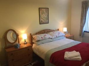 a bedroom with a bed with two lamps and a mirror at Rondo, Ballymena, Nr Ireland in Ballymena