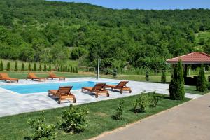 a group of benches sitting next to a swimming pool at Holiday Home Dalija in Otočac