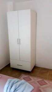 een witte kast in een kamer met een tapijt bij Apartman Tatjana in Sutomore