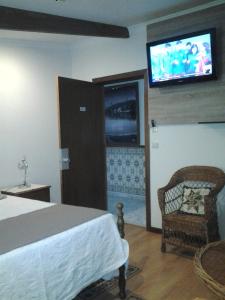 a bedroom with a bed and a tv on the wall at Hotel Azibo e Restaurante in Podence