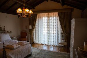 ein Schlafzimmer mit einem Bett und einem großen Fenster in der Unterkunft Casa do Telhado in Guimarães