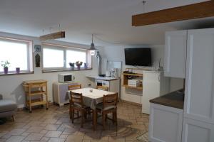 a kitchen with a table and a small kitchen with a table and chairs at IL LILLA in Ankaran