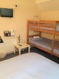 Zimmer mit 2 Etagenbetten und einem Tisch in der Unterkunft Marlow Lodge in Blackpool