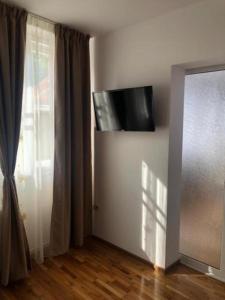 Habitación con TV en la pared junto a una ventana en CASA ALISE-LUISE, en Brasov