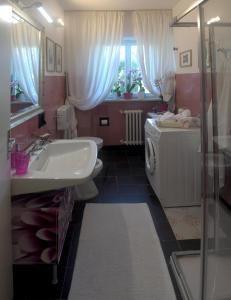 a bathroom with a sink and a washing machine at PARVA SED APTA MIHI in Fermo