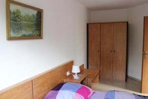 シュトロームベルクにあるFerienwohnung Holunderwegのベッドルーム1室(ベッド1台付)、木製キャビネットが備わります。