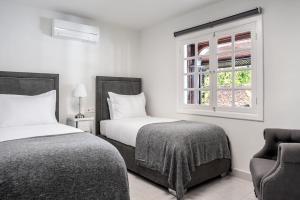 une chambre avec deux lits et une fenêtre et une chaise dans l'établissement Drago by AGM Resorts, à Puerto del Carmen 47 autres photos