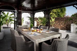 une table et des chaises en bois sur une terrasse dans l'établissement Drago by AGM Resorts, à Puerto del Carmen