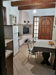 una cucina con tavolo, sedie e camino di Agriturismo Pettinari a Marina di Grosseto