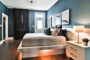 1 dormitorio con paredes azules y 1 cama con mesa en Luxury Apt w/ Spectrum Mood Lighting - Historic Cherokee Street Antique Row, en Maryland Heights