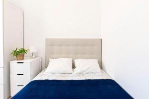 ein weißes Schlafzimmer mit einem blauen und weißen Bett in der Unterkunft MantaGarden in Manta Rota