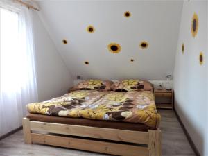 1 dormitorio con 1 cama con flores en la pared en Podkrovní apartmán v Zátiší en Doksy