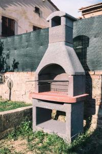 um forno de pizza de pedra sentado ao lado de uma parede em Casa Erika em Palaia