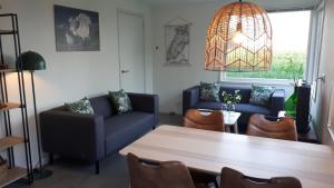 sala de estar con sofá azul y mesa en Bungalow Groen, en Den Burg