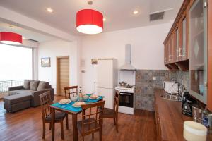 a kitchen and living room with a table and chairs at Calypso Apartments in Vathi