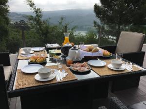 a table with plates of food on it with a view at Refúgio do Tâmega in Penafiel