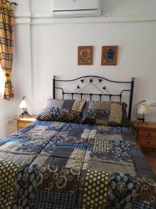 Una cama con edredón en un dormitorio en Alojamiento valeria, en Arroyo Frío