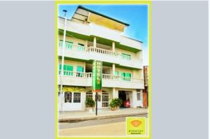 a large white building with balconies on a street at Hotel Mansión del Cesar in Aguachica