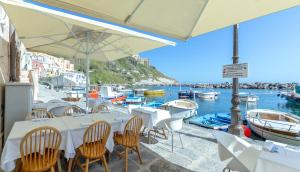 a restaurant with tables and chairs and boats in the water at San Michele in Procida