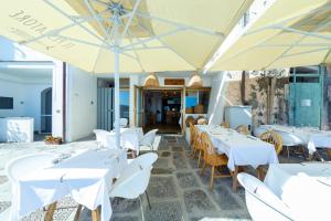 a restaurant with white tables and chairs and umbrellas at San Michele in Procida