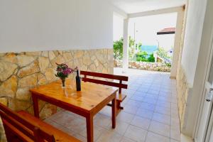 Una mesa de madera con un jarrón de flores encima. en Apartments Petrovac, en Zavala