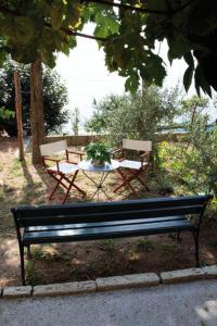 un banco de parque y una mesa con una planta. en Locanda Tramonti, en La Spezia