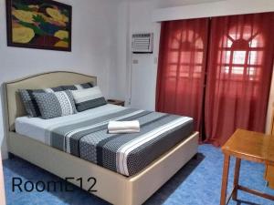 a bedroom with a bed and a red curtain at Eriko's House in Boracay