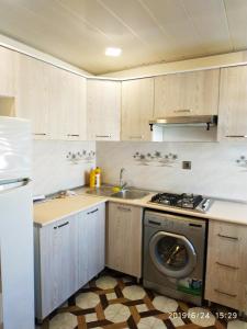a kitchen with a stove and a washing machine at Caspian Star in Sumqayyt
