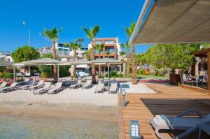 a group of lounge chairs and umbrellas on a beach at Marisol Boutique Hotel in Gundogan