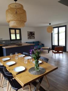 a dining room table with a vase of flowers on it at Entre mer et montagne, en plein maquis in Vallecalle