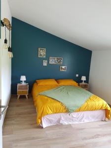 a bedroom with a large bed with a blue wall at Entre mer et montagne, en plein maquis in Vallecalle