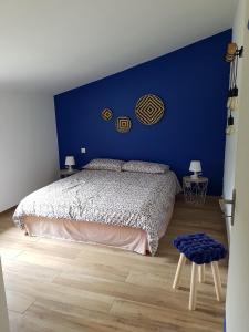 a blue bedroom with a bed and a blue wall at Entre mer et montagne, en plein maquis in Vallecalle