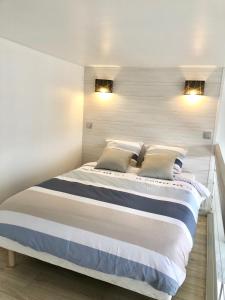 een slaapkamer met een groot bed met 2 kussens bij Charmant Duplex Trouville-Deauville in Trouville-sur-Mer